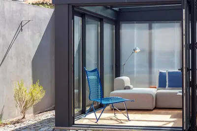 a blue chair sitting on a patio next to a couch at Chic Campanhã Home w Free Parking by LovelyStay in Porto