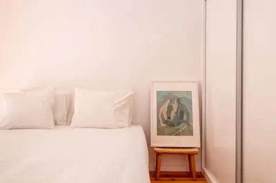 a white bed with white pillows and a picture at Chic Campanhã Home w Free Parking by LovelyStay in Porto