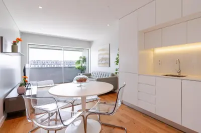 a kitchen and dining room with a white table and chairs at Stylish Home with Balcony & Garage by HostWise in Porto