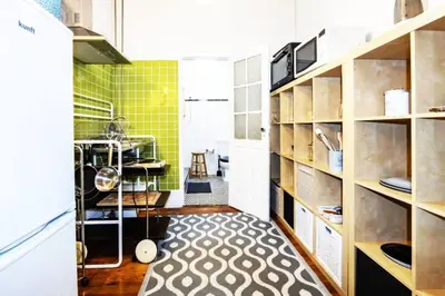 a small kitchen with wooden shelves and green tiles at Love&Life - Cosy&Central in Porto
