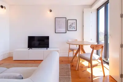a living room with a table and a tv at Stylish & Sunny 2BR near Heroísmo by LovelyStay in Porto