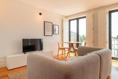 a living room with a couch and a tv and a table at Stylish & Sunny 2BR near Heroísmo by LovelyStay in Porto