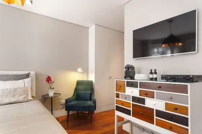 a bedroom with a bed and a dresser and a chair at Luxury Apartment In Cardosas in Porto