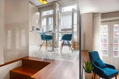 a kitchen with a table and two blue chairs at Luxury Apartment In Cardosas in Porto