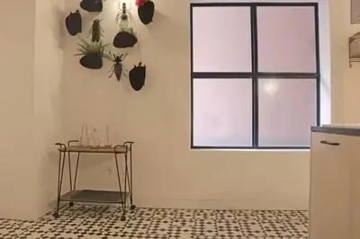 a white kitchen with a table and a window at Formosa IN in Porto