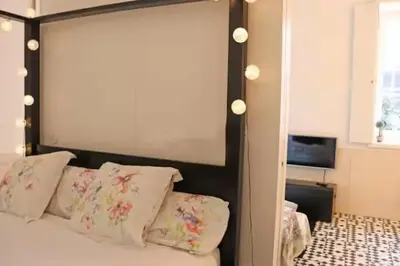 a bed with a large headboard and pillows in a bedroom at Formosa IN in Porto