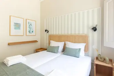 a bedroom with a white bed with two pillows at Porto Haven - Under the Luís I Bridge in Porto