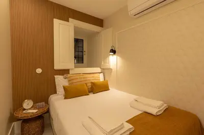 a small bedroom with a bed with white sheets at Porto Haven - Under the Luís I Bridge in Porto