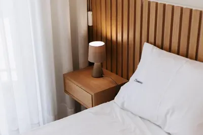 a bedroom with a bed and a lamp on a night stand at O Navegador in Porto