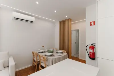 a room with a table with chairs and a fire extinguisher at O Navegador in Porto