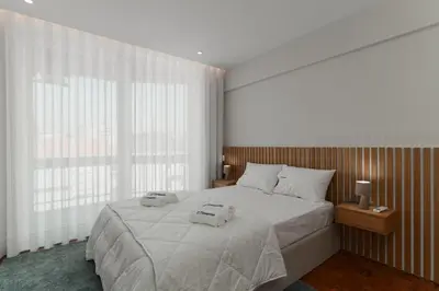 a bedroom with a large bed with two towels on it at Fernão de Magalhães in Porto