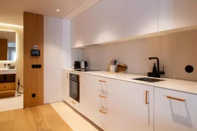 a kitchen with white cabinets and a sink at Verde Almada 3d by LovelyStay in Porto