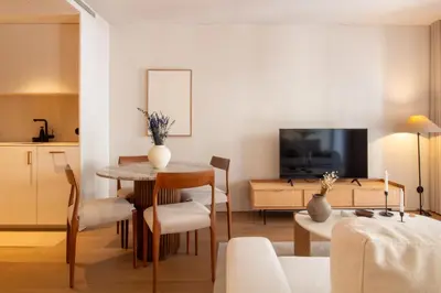 a living room with a table and chairs and a television at Verde Almada 3d by LovelyStay in Porto