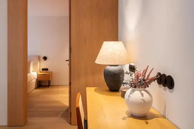 a table with a lamp and a vase on it at Verde Almada 3d by LovelyStay in Porto