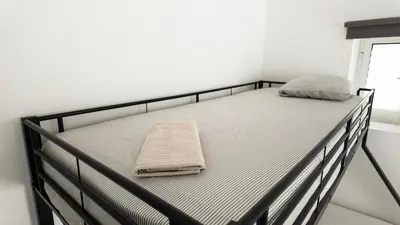 a bed with a blanket and two pillows on it at Bonfim Residence in Porto