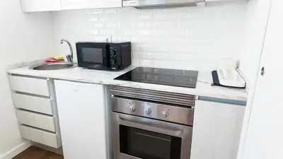a small kitchen with a stove and a microwave at Bonfim Residence in Porto