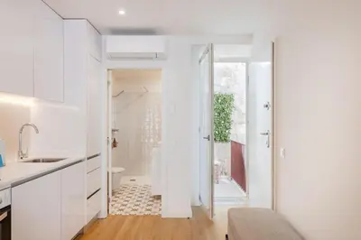 a white bedroom with a large bed with pillows at Studio Central | 111 Collection in Porto