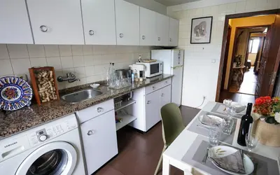 a kitchen with a sink and a washing machine at Apartamento T3 perto do Centro do Porto, Check-in 24 horas,Cozinha totalmente equipada, Wi-Fi 44Mbps, Propriedade Confortável e Espaçosa, Com Vaga de Carro Pública, Adequada para famílias, hóspedes em negócios e grupos de amigos e nomades digitais in Porto