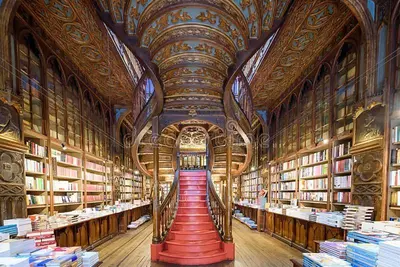 a large library with lots of books and a staircase at Apartamento T3 perto do Centro do Porto, Check-in 24 horas,Cozinha totalmente equipada, Wi-Fi 44Mbps, Propriedade Confortável e Espaçosa, Com Vaga de Carro Pública, Adequada para famílias, hóspedes em negócios e grupos de amigos e nomades digitais in Porto