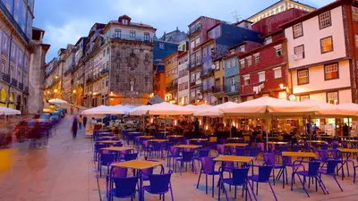 a city street with tables and chairs and buildings at Apartamento T3 perto do Centro do Porto, Check-in 24 horas,Cozinha totalmente equipada, Wi-Fi 44Mbps, Propriedade Confortável e Espaçosa, Com Vaga de Carro Pública, Adequada para famílias, hóspedes em negócios e grupos de amigos e nomades digitais in Porto