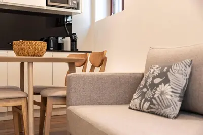 a couch with a pillow on it next to a table at Central Porto Hideaway with Sunny Terrace by Lisbeyond in Porto