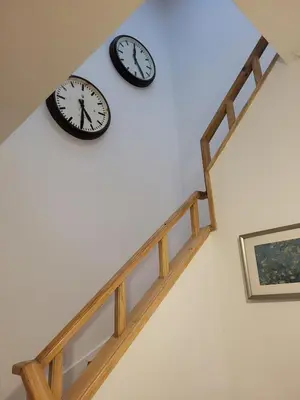 two clocks on the wall above a staircase at Casa da travessa familial e com terraço in Porto
