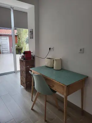 a table with a chair in a room with a door at Casa da travessa familial e com terraço in Porto