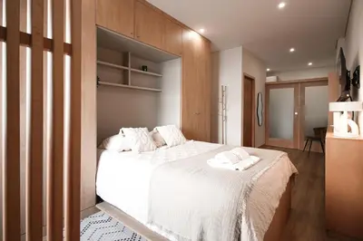 a bedroom with a large bed with white sheets at Bleu Alma Apartment in Porto