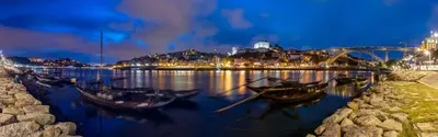 a city at night with boats in the water at Quinta de Sao Marcos Suite Deluxe in Vila Nova de Gaia