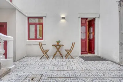 a patio with two chairs and a table and a red door at OPORTO GUEST Downtown Escape in Porto