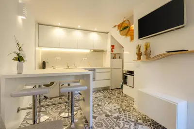 a room with a white cabinet with paintings on the wall at Cozy Downtown House in Porto
