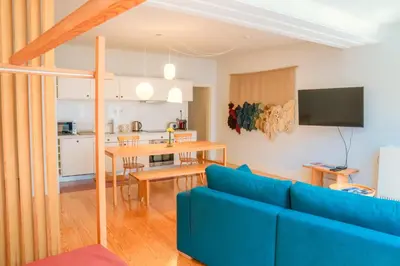 a living room with a blue couch and a kitchen at Porto Breeze in Porto