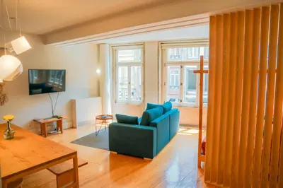 a living room with a blue couch and some windows at Porto Breeze in Porto
