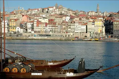 two boats in the water with a city in the background at Open-Air Terrace Studio in Historic Heart of Porto in Porto