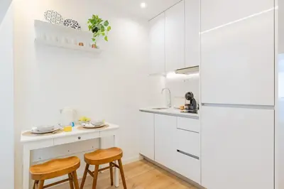 a kitchen with white cabinets and two stools at Studio Dash | 111 Collection in Porto