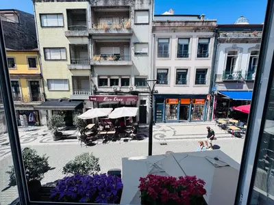 a view of a city street from a window with purple flowers at Majestic Hostel Porto in Porto