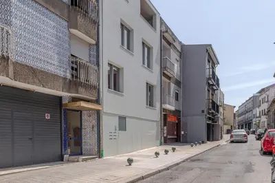 a row of buildings on a street with birds on the sidewalk at Premium Apartments with Garage by HostWise in Porto