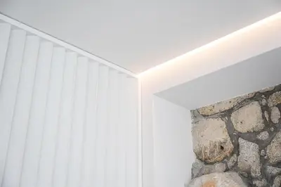 a room with a white ceiling and a stone wall at GuestReady - The perfect urban retreat in Porto