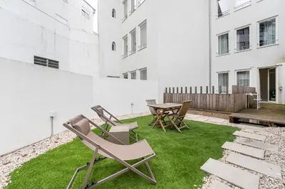 a patio with chairs and a table and grass at GuestReady - The perfect urban retreat in Porto