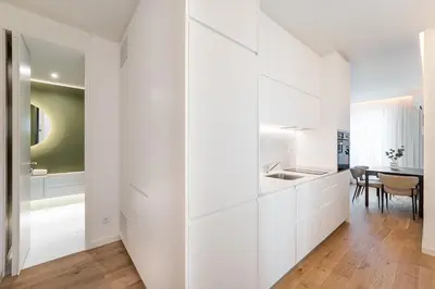 a white kitchen with white cabinets and a table at GuestReady - The perfect urban retreat in Porto