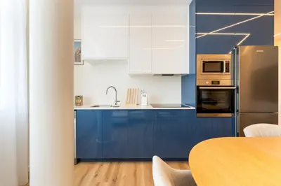 a kitchen with blue cabinets and a table at GuestReady - Urban retreat in Porto in Porto