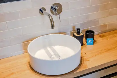 a white sink on a wooden counter with a faucet at Balcony Garden Views at Terracotta Collection in Porto