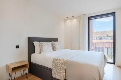 a bedroom with a large bed and a large window at Balcony Garden Views at Terracotta Collection in Porto