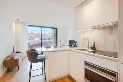 a kitchen with a counter and a chair and a window at Balcony Garden Views at Terracotta Collection in Porto