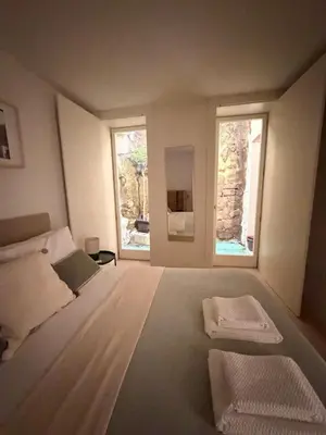 a bedroom with a large bed with two windows at Guindais River View I in Porto