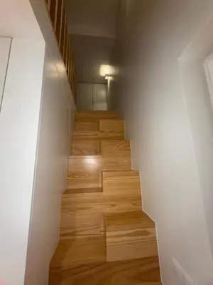 a staircase with wooden floors and a white wall at Jardins de Cedofeita Apartment by Oporto Soul in Porto