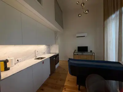 a kitchen with white cabinets and a blue counter top at Jardins de Cedofeita Apartment by Oporto Soul in Porto