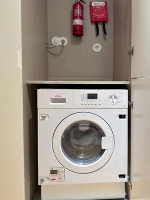 a washer and dryer in a box with a fire extinguisher at Luxurious Flat in Award-Winning Building in Porto