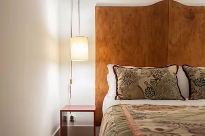 a bedroom with a bed with a wooden headboard and a lamp at Luxurious Flat in Award-Winning Building in Porto