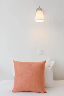 an orange pillow on a white bed with a lamp at Liiiving in Gaia - Douro Balcony View in Vila Nova de Gaia